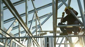 Contractor Worker with Walkie Talkie in Hand on the Steel Frame of the House video