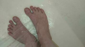 Legs with veins for health are washed with a shower video