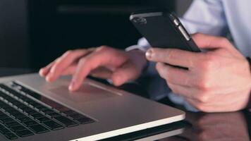 Caucasian Businessman Working Online Using His Laptop Computer and the Smartphone. Mobile Devices Sync. video