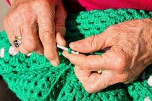 Old woman with knitting needles and wool photo