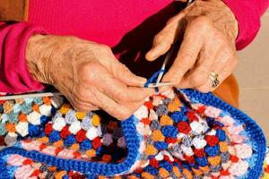 Old woman with knitting needles and wool photo
