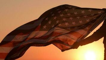 americano patriota con Estados Unidos bandera durante escénico puesta de sol video