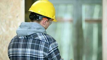 männlich Konstruktion Arbeiter setzt auf Helm und Handschuhe An. video