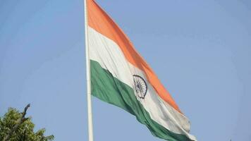 India flag flying high at Connaught Place with pride in blue sky, India flag fluttering, Indian Flag on Independence Day and Republic Day of India, tilt up shot, Waving Indian flag, Har Ghar Tiranga video