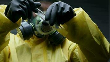 mannetje in Hazmat pak mengsels stof in test buis. video