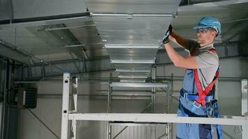 caucásico masculino aire acondicionamiento profesional montaje ventilación conducto en techo de interior de grande edificio. video
