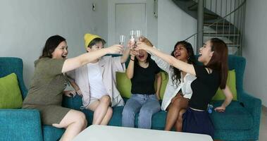 jung asiatisch Frau Gruppe sich unterhalten Klatsch Plaudern singen trinken Prost Party Spaß genießen betrunken Prost komisch Gesichter Ausdruck auf Blau Leben Zimmer Sofa video