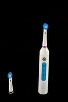 Electric toothbrush on black background photo