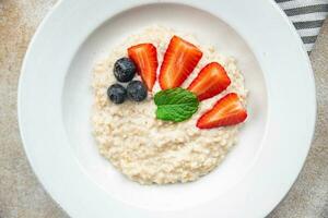 oatmeal porridge with berries tasty breakfast healthy meal food snack on the table copy space food background rustic top view photo