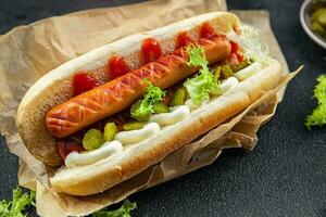 hot dog sandwich bun, sausage, gherkin, ketchup, mayonnaise fast food meal food snack on the table copy space food background rustic top view photo