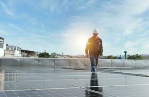 technician inspecting solar panels on factory roof Check and maintain the solar panel roof A team of technicians installing solar panels on the roof of a high-rise building photo