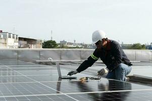 technician inspecting solar panels on factory roof Check and maintain the solar panel roof A team of technicians installing solar panels on the roof of a high-rise building photo