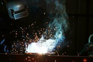 industrial trabajadores a acero estructura soldadura planta un soldador es soldadura metal partes en un pequeño taller. foto