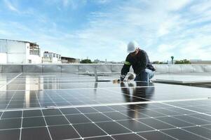 technician inspecting solar panels on factory roof Check and maintain the solar panel roof A team of technicians installing solar panels on the roof of a high-rise building photo