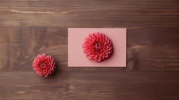 Top View of Pink Paper Card Mockup with Beautiful Dahlia Flowers on Wooden Table, . photo