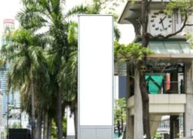 Mock up white LED display vertical billboard on tower pole with cityscape view. clipping path for mockup photo