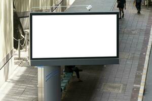 Outdoor pole LED display billboard with mock up white screen on footpath. clipping path for mockup photo