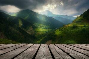 Beautiful background with misty mountains and empty wooden table in nature outdoor. Natural template landscape photo