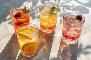 Summer cocktail in the sun. Fresh juicy drink in glass with shadow make trendy pattern on gray marble background. photo