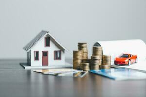 Car and house model with coins and financial document on wooden table. Asset approval concepts purchases to buy a car and a house. Ideas for home buying checklist home loan tax photo