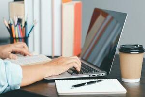 Education concept. Close up of female student make notes hand typing in laptop study online on computer from home. Woman typing in computer talking distant on webcam virtual zoom call on laptop. photo