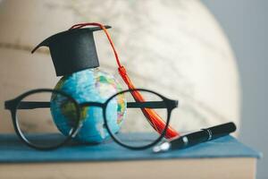 Graduation cap with Earth globe. Concept of global business study, abroad educational, Back to School. Education in Global world, Study abroad business in universities in worldwide. language study photo