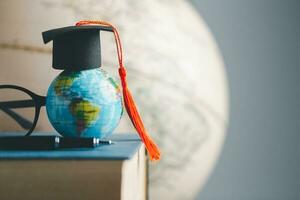 graduación gorra con tierra globo. concepto de global negocio estudiar, extranjero educativo, espalda a escuela. educación en global mundo, estudiar extranjero negocio en universidades en mundial. idioma estudiar foto