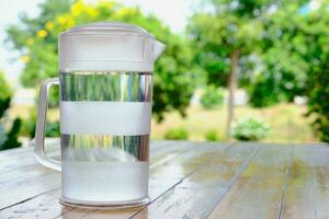 agua bebida en claro el plastico jarra en madera mesa foto