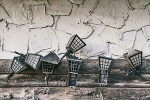 Old lamps hung on a concrete-wood wall. photo