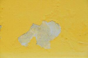 Peeling paint on the wall. Vintage old concrete yellow empty for design, pattern, cover, overlay texture, background and other, Surface of cement or concrete background. photo