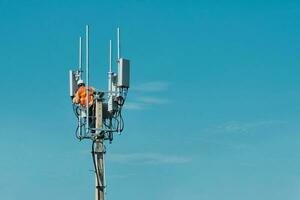 Technician on telecommunication antenna tower photo