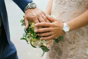 manos de el novia y novio son en el Boda ramo de flores foto