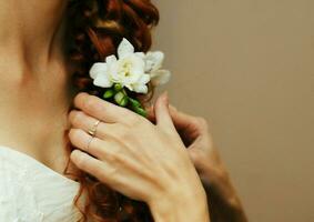 The bride is braided and decorated with white freesia flowers photo
