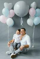 un elegante padre con su niño de cuatro años hijo en el antecedentes de globos, celebrando un cumpleaños o del padre día foto
