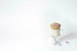 Dalgon's trending drink is coffee. Coffee mug, lilac and marshmallow on a white background. Copying space photo