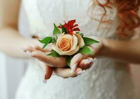 un flor en el ojal para el novio desde un naranja Rosa en el palmas de el novia de cerca foto