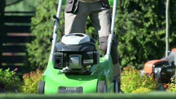 Garden Worker with Gasoline Mower Machine Trimming Backyard Grass. video