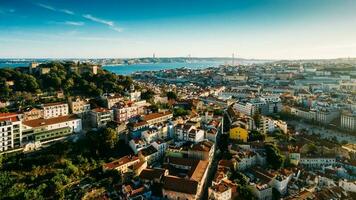 Aerial drone view of Castelo Sao Jorge on foreground with Lisbon, Portugal baixa district in background including 25 April Bridge photo