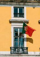 portugués bandera en amarillo fachada reflejando en ventana foto