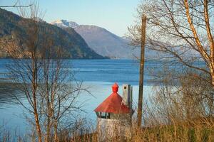 nordfjord en Noruega. ver de montañas cubierto con nieve. primer plano un faro foto