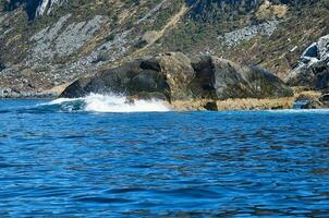 norway on the fjord, spray on rocks. Water splashes on the stones. Coastal landscape photo