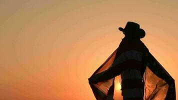 cow-boy en jouant avec américain drapeau pendant scénique le coucher du soleil. indépendance journée fête video