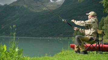 caucásico pescador en su 30s mosca pescar en el glacial lago video