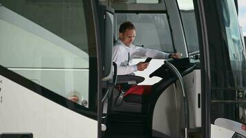 caucasiano ônibus treinador motorista navegando Internet em a ônibus parar. video