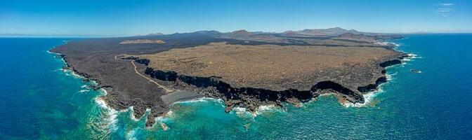 Drone panorama of volcanic coast near El Golfo on Lanzarote with Playa del Paso during daytime photo