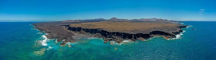 Drone panorama of volcanic coast near El Golfo on Lanzarote with Playa del Paso during daytime photo