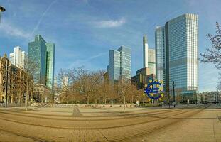 Panoramic picture from Williy-Brandt square in Frankfurt over skyline with euro sign in morning light photo