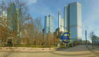 Panoramic picture from Williy-Brandt square in Frankfurt over skyline with euro sign in morning light photo