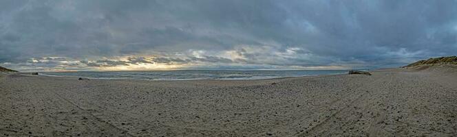 Panoramic picture over a beach in Jutland in rough weather photo