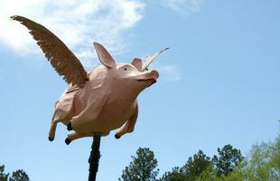 Whimsical Flying Pig Outdoor Sculpture in photo